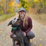 Dr. Kaitlyn Shaheen pictured in the woods with her grey dog